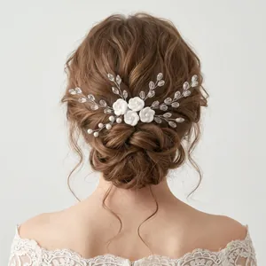 Handmade bridal hair comb with white clay flowers and pearls for elegant wedding styles.