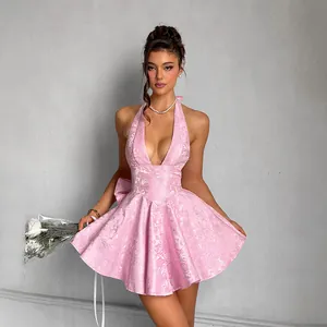 Elegant detail showing pink jacquard halter dress with a large decorative back bow