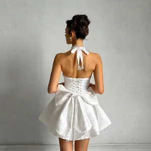 Back detail of elegant white jacquard halter dress with a large decorative bow