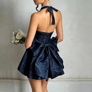 Detailed back view of an elegant navy blue jacquard halter dress with a large decorative bow.