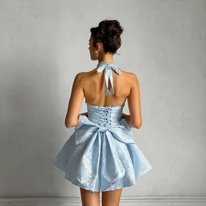 Detailed back view of a light blue jacquard halter mini dress with a large bow decoration