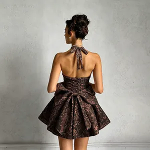 Back detail of a jacquard halter dress with a large bow and lace-up corset back.