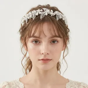 Détail d'un bandeau de mariée élégant avec feuilles argentées et perles blanches sur modèle.