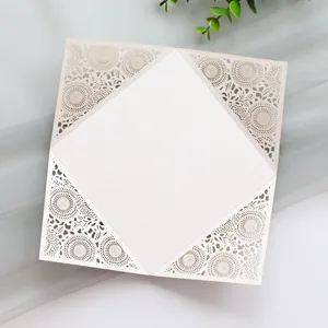 Close-up showing intricate laser-cut floral patterns on an elegant cream wedding invitation.