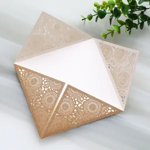 Detail shot of shimmering gold laser-cut floral wedding invitation with lace pattern
