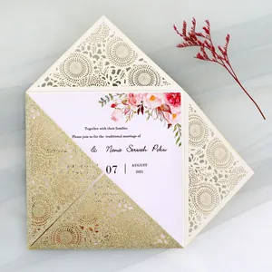 Close-up of elegant laser-cut gold glitter wedding invitation with floral inner card detail