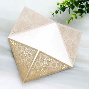 Detailed view of laser-cut wedding invitation with gold glitter and lace patterns