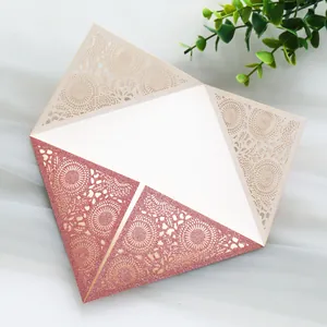 Exquisite macro detail of rose gold glitter and laser-cut lace pattern wedding invitation