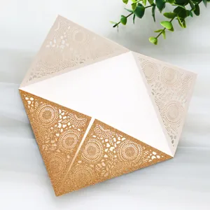 Detailed view of laser-cut gold glitter wedding invitation with intricate lace pattern
