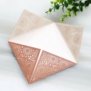 Macro view of laser-cut lace pattern on rose gold glitter wedding invitation card