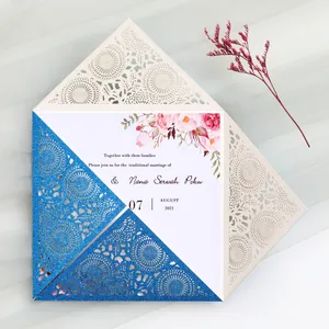 Close-up of laser cut wedding invitation with blue glitter finish and floral details