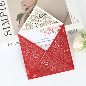 Close-up of a glitter red laser-cut wedding invitation with intricate lace patterns.