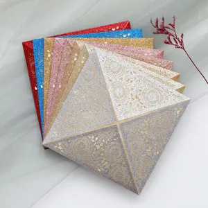Detail view of multi-color laser-cut glitter wedding invitations with elegant lace patterns