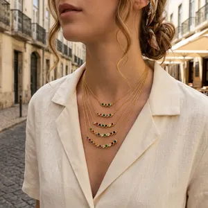 Detail view of layered 18K gold-plated necklaces with colorful rainbow gemstones.