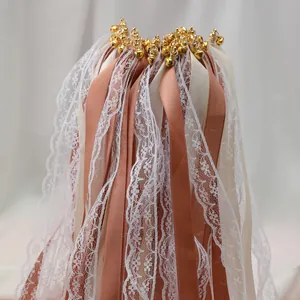 Gros plan de baguettes de ruban de mariage avec dentelle, rubans et cloches dorées