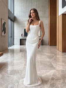 Elegant white boned corset maxi dress with cowl draping in a luxury hall setting