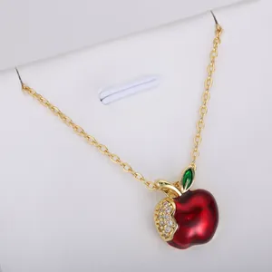 Elegant red apple fruit pendant necklace featuring gold finish and shimmering crystal accents