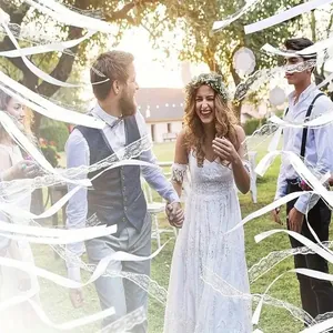 Scène de mariage avec des baguettes de ruban en dentelle blanche autour d'un couple