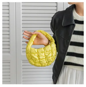 Primo piano di una mini borsa nuvola trapuntata gialla con texture tipo piumino