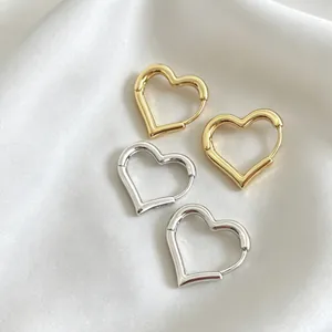 Detailed view of minimalist hollow heart-shaped hoop earrings in gold and silver finishes