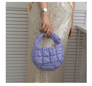 Dettaglio della borsa a nuvola trapuntata viola tenuta da una modella