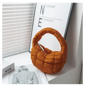 Vista dettagliata di una borsa a nuvola trapuntata arancione con texture plissettata