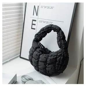 Primo piano di borsa a mano nuvola nera pieghettata con trama a bolle trapuntata.