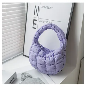 Dettaglio della morbida trama trapuntata viola e del manico di questa borsa nuvola