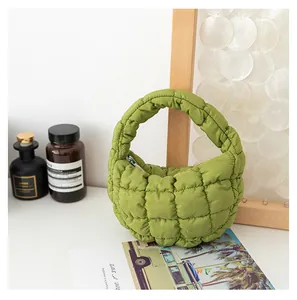 Primo piano di una mini borsa a mano verde trapuntata con morbida trama a nuvola