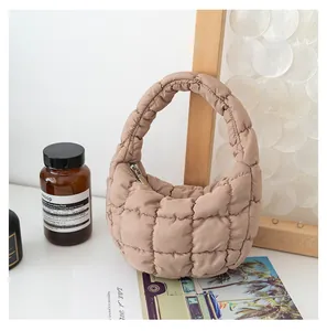 Elegante mini borsa trapuntata beige presentata in un raffinato contesto di studio lifestyle