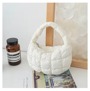 Dettaglio di una borsa a mano bianca trapuntata a nuvola con consistenza soffice e moderna