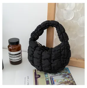 Primo piano di una borsa a nuvola trapuntata nera in un ambiente moderno