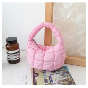 Mini borsa a nuvola rosa trapuntata in un ambiente lifestyle minimalista con decori.