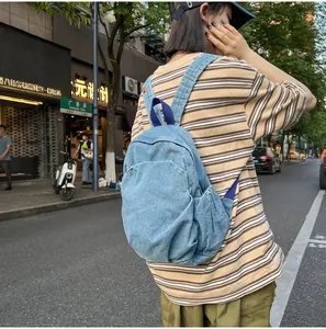 Elegante mochila de mezclilla lavada vintage para mujer usada en una calle urbana