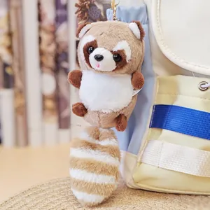 Nahaufnahme eines niedlichen Waschbär Plüschanhängers an einem cremefarbenen Rucksack