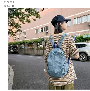 Modelo con la mochila de mezclilla azul vintage en un entorno urbano con estilo.