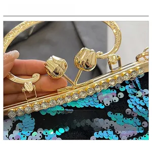 Macro detail of the elegant golden floral clasp and blue sequins on a luxury evening bag
