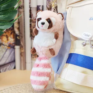 Detailansicht eines niedlichen rosa Waschbär-Plüsch-Schlüsselanhängers an einem Rucksack