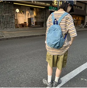 Mochila de mezclilla lavada para mujer con un estilo casual urbano por la calle