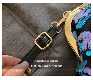 Detailed view of the gold adjustable buckle and leather strap on sequin evening bag