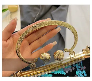 Close-up of golden metal handle with floral clasp on sequin evening clutch bag