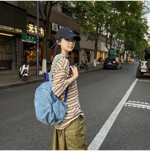 Mochila de mezclilla lavada vintage para mujer en un estilo urbano informal.