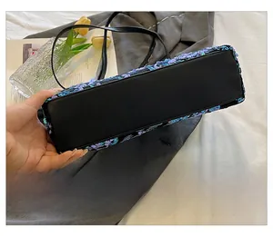 Close-up of the rectangular bottom and purple sequin details of an evening bag