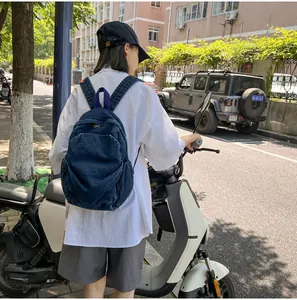 Mujer asiática con una mochila de mezclilla lavada retro junto a un scooter blanco