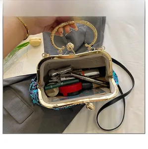 High-angle detail view showing spacious interior of sequin evening clutch bag with cosmetics