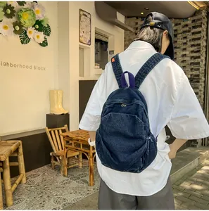 Detalle de una mochila vintage de denim lavado en una elegante cafetería al aire libre