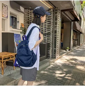 Mochila de mezclilla lavada de moda usada por una modelo en un entorno urbano informal