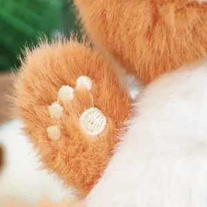 Detaillierte Nahaufnahme der Pfote des niedlichen Waschbär-Plüschanhängers mit Stickerei