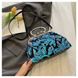 Close-up of blue sequin embroidery on vintage evening bag with gold frame