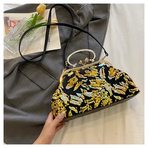 Close-up of elegant black evening clutch bag with gold sequins and metal frame handle